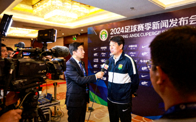记者在新闻发布会现场采访足球教练
