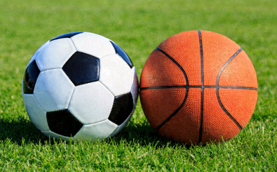 足球与篮球并置在绿色草坪上，象征综合体育